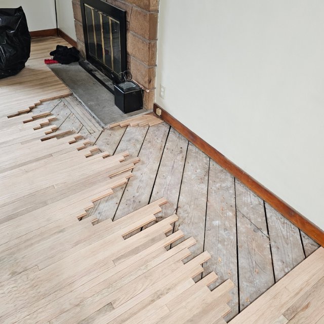 Hardwood floor installation in progress, with new planks being laid over the subfloor by NV Floors LLC in Pittsburgh, PA.