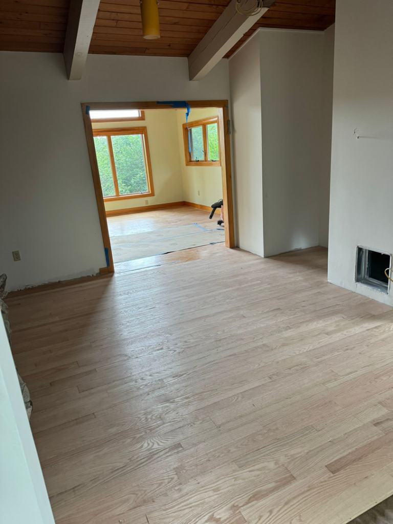 Hardwood floor installation in progress, showing a newly floored room and another under renovation by International Wood Floors in Gaithersburg, MD