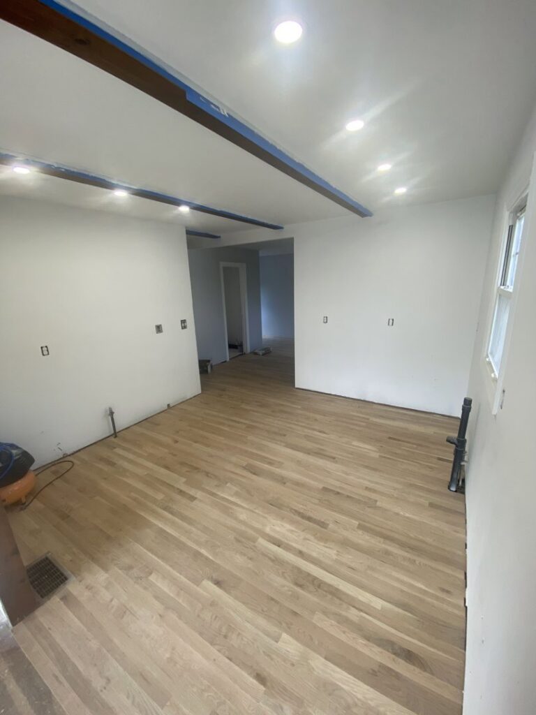 Interior room renovation featuring new hardwood floor installation and recessed lighting by Amaro home improvement llc in Danbury, CT.