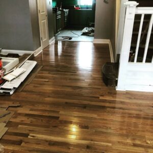 Newly installed hardwood flooring in a hallway or living area, showing ongoing work by Ruach Home Services in Laurel, MD.