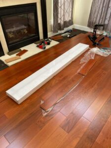 Hardwood floor installation tools and new planks near a fireplace by Just Floor It Hardwood Floors LLC in Philadelphia, PA