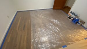 Hardwood floors covered with plastic sheeting for protection during refinishing or painting by T&K Services in Idaho Falls, ID