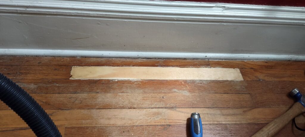 Hardwood floor repair in progress with a new wood patch installed by Handyashby in Saint Joseph, MO.