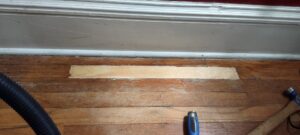 Hardwood floor repair in progress with a new wood patch installed by Handyashby in Saint Joseph, MO.