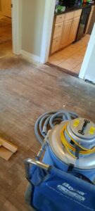 A professional floor sanding machine in use on hardwood flooring by Quick Sand Flooring & Install LLC in Millcreek, UT.