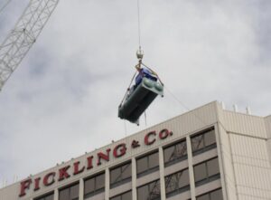 A crane operated by Hays Service lifting large HVAC equipment onto a commercial building in Macon, GA