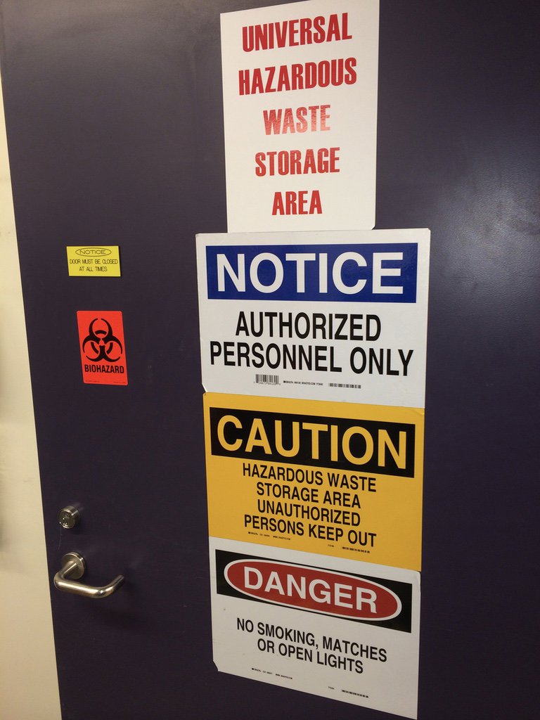 Signs indicating a universal hazardous waste storage area, managed by MLi Environmental in South Portland, ME.