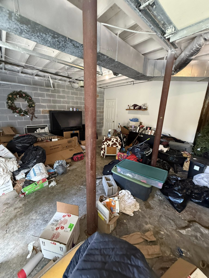 A heavily cluttered basement filled with trash bags and boxes, ready for junk removal by Marc & Park Junk Removal, LLC in Birmingham, AL.