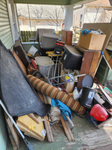 A heavily cluttered porch overflowing with various junk items, ready for removal by C&J junk removal llc in Akron, OH.