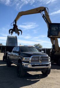 Heavy equipment, an excavator with a grapple, next to a dump truck, used for large-scale junk removal by Southwestern Dumpster Rental and Junk Removal in Peoria, AZ.