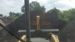 Heavy equipment moving a large pile of compost or organic waste at Windham Solid Waste Management District in Brattleboro, VT.