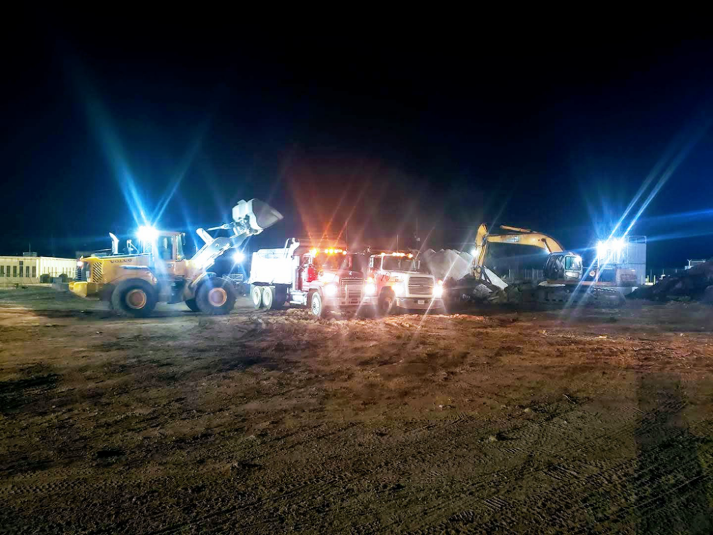 Heavy equipment including a front loader and excavator working at night for Eco Recycling Group in Macon, GA