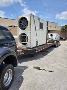 Large industrial HVAC unit being transported on a flatbed trailer by Jugganott Recycling, LLC in Orlando, FL.