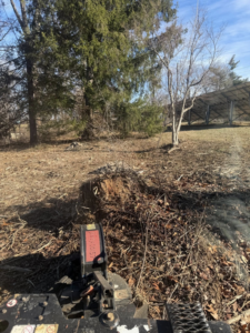Heavy machinery with an attachment clearing brush and stumps, showing land clearing by Farm Services in Scottown, OH.