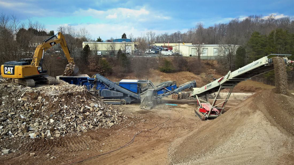 Heavy machinery processing piles of construction debris at Eco Recycling Group in Macon, GA