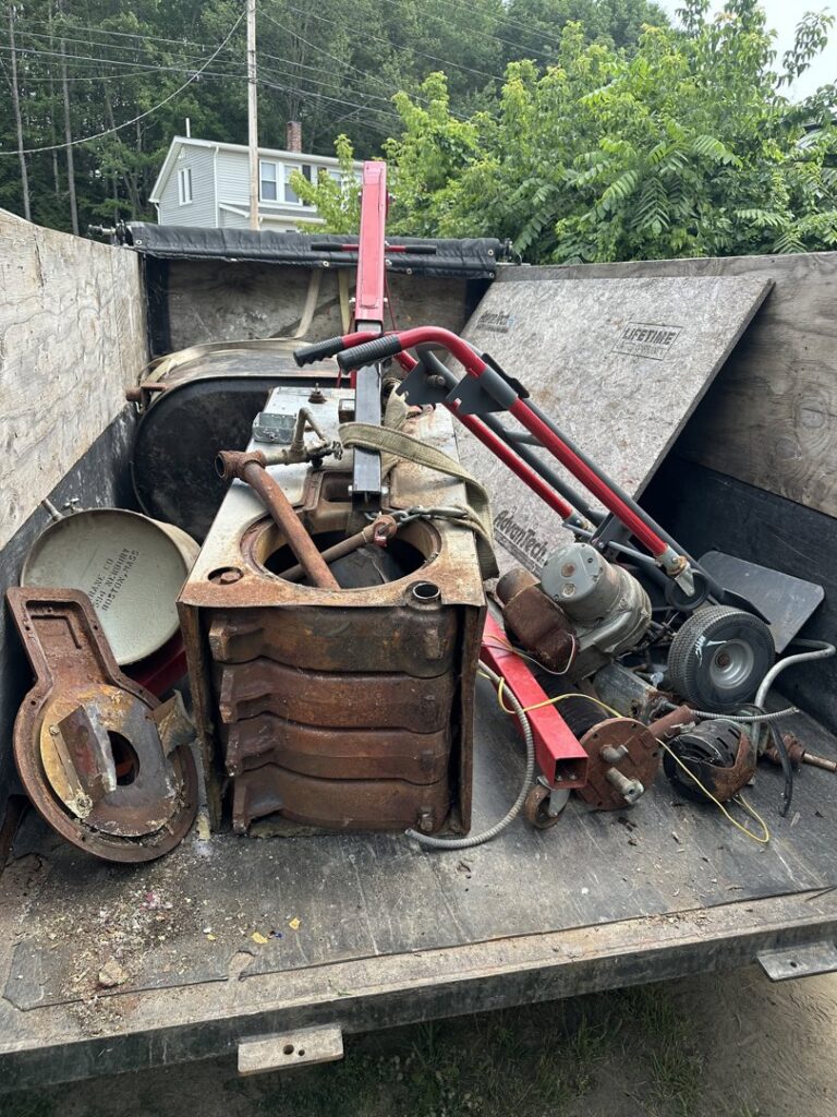 A trailer filled with heavy metal junk and old machinery for removal by CleanSite Solutions in Windham, ME.