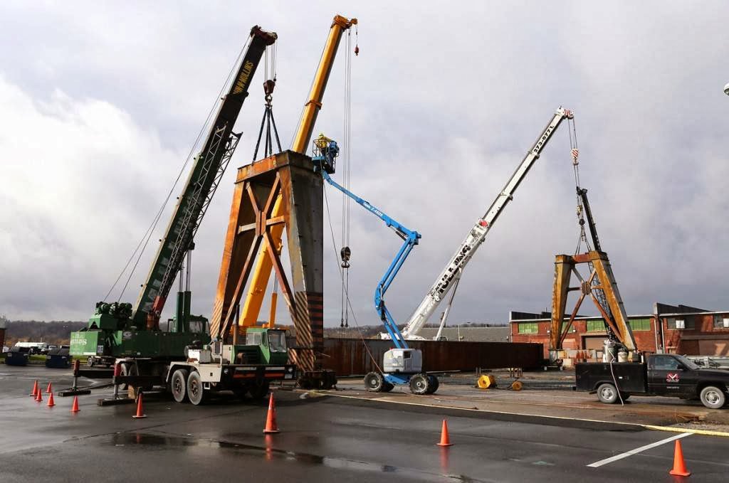 Heavy rigging operation with multiple cranes and a boom lift working on a large steel structure by Mullins Rigging in Green Island, NY