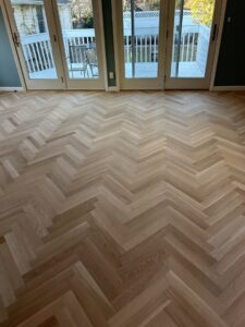 Room featuring a beautiful herringbone pattern hardwood floor installed by Diamond Flooring LLC in Boston, MA