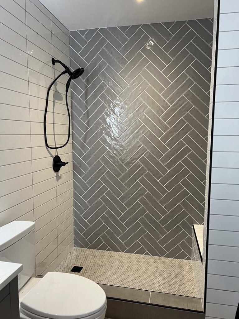 A newly installed shower with herringbone tile walls by Jocia Construction Services in Gilbert, AZ.