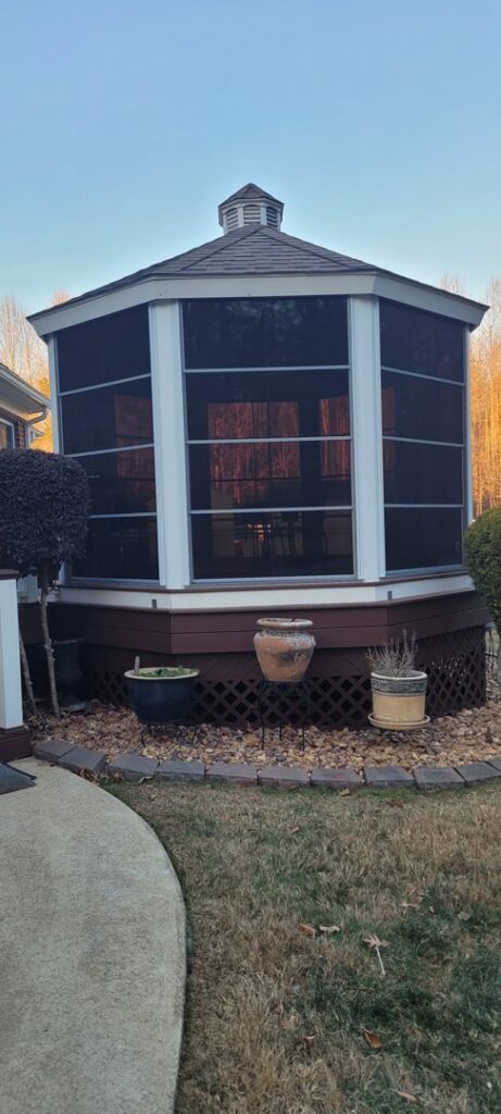 A newly constructed hexagonal screened gazebo in a backyard by X-Terior Techs in Henrico, VA.