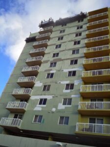 High-rise building exterior undergoing renovation and surface preparation by Vico Painting Contractors in Hialeah, FL