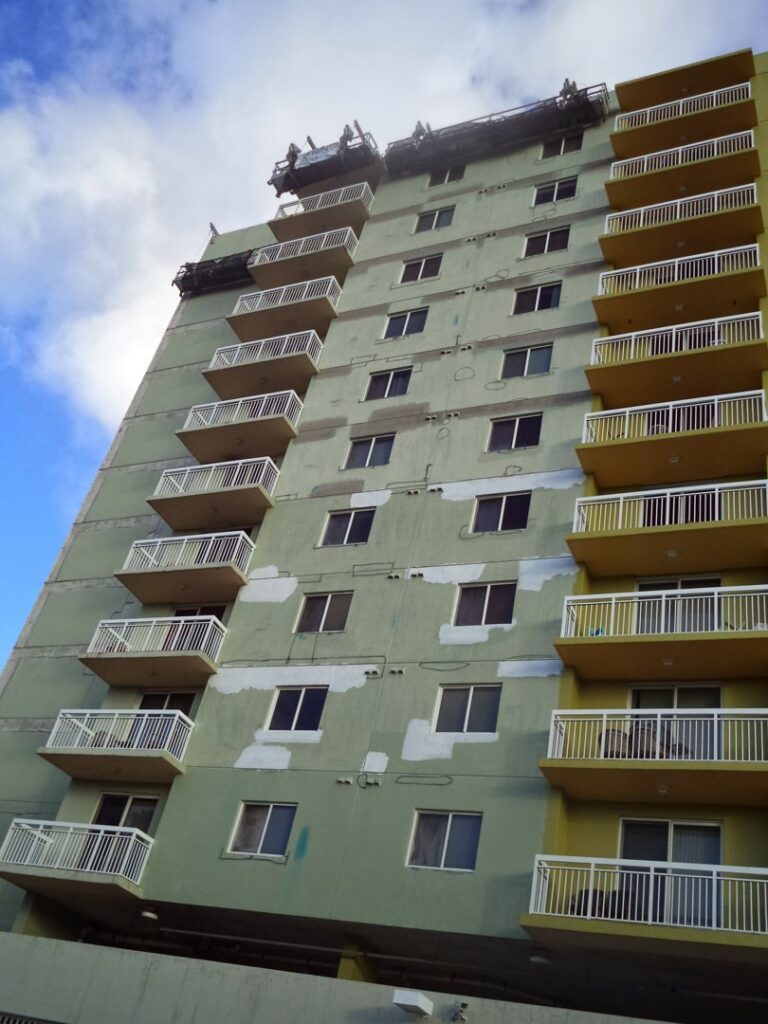 High-rise building exterior undergoing renovation and surface preparation by Vico Painting Contractors in Hialeah, FL