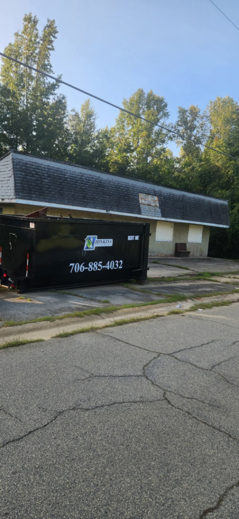 A Hinkins Disposal llc roll-off dumpster placed at a commercial property for general junk removal in Augusta, GA.