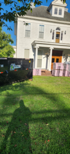 A Hinkins Disposal llc roll-off dumpster placed at a house undergoing renovation for junk removal in Augusta, GA.