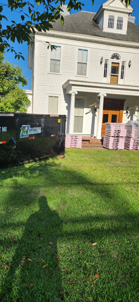 A Hinkins Disposal llc roll-off dumpster placed at a house undergoing renovation for junk removal in Augusta, GA.