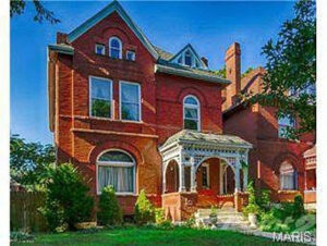 The exterior of a historic red brick house with an ornate porch, a project completed by Major League Handyman and Remodeling in St. Louis, MO.