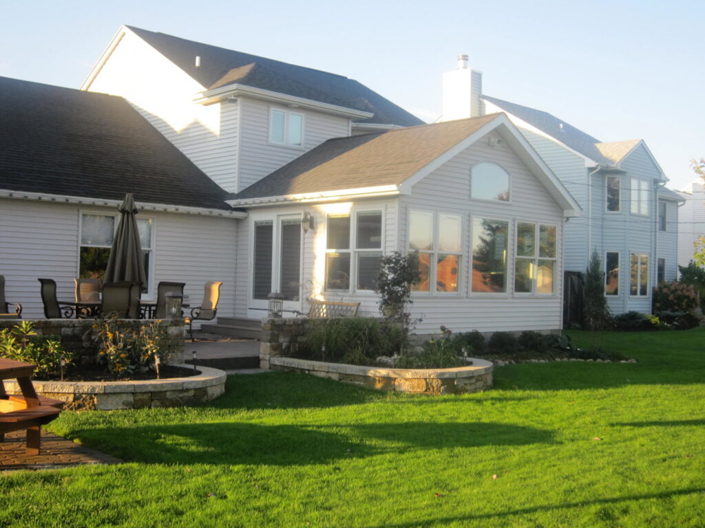 The exterior of a completed sunroom home addition, blending seamlessly with the existing house by Hibbard Home Improvement in Williamsville, NY.