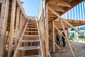 Home construction framing with workers on site by Overstreet Builders, Inc. in Naperville, IL.