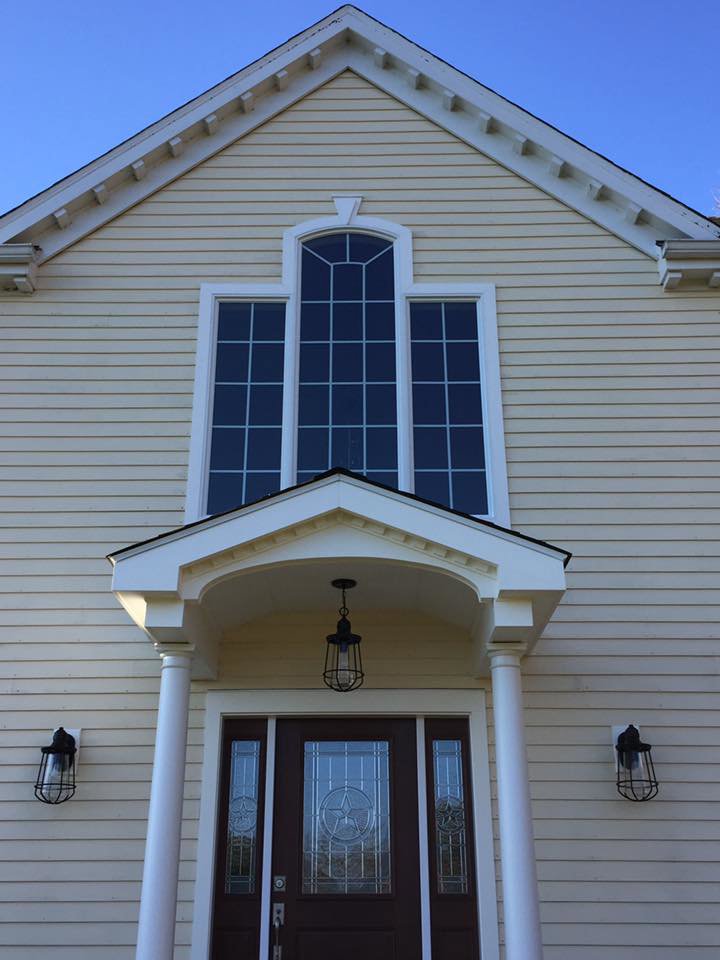Completed home exterior facade renovation with new siding, windows, and an updated porch by Byrd's Contracting, LLC in Bristol, CT.