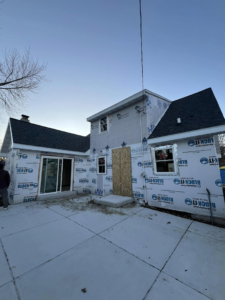 A home exterior undergoing renovation with new house wrap and sliding door installation by Sandoval Contracting & Remodeling in Menasha, WI.