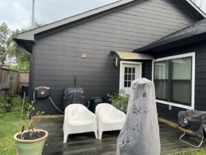 A home exterior with new dark siding and a wooden deck installed by All Star Construction, Inc. in Houston, TX.