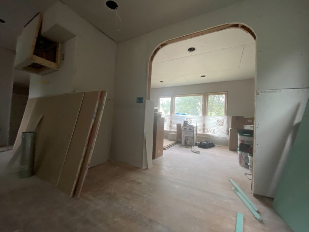 A home interior undergoing renovation with stacked drywall sheets and exposed framing, a project by Handy Fix Co. in Cleveland, OH.