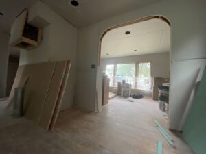 A home interior undergoing renovation with stacked drywall sheets and exposed framing, a project by Handy Fix Co. in Cleveland, OH.