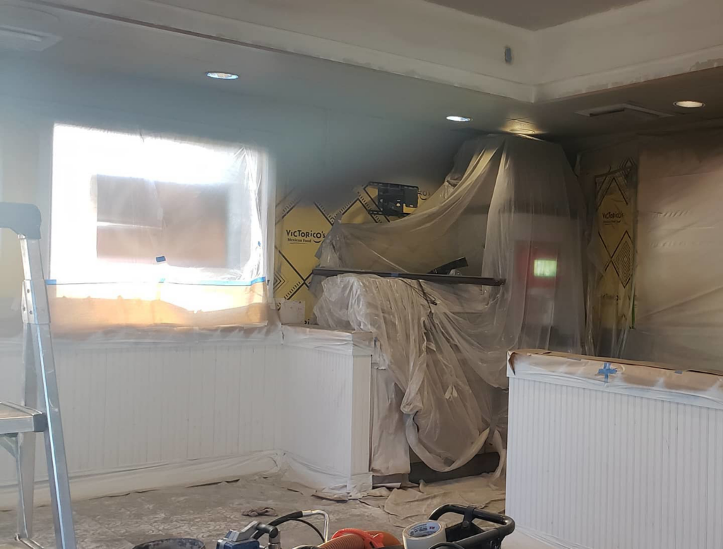 A home interior renovation in progress with tools, ladders, and plastic-covered windows by RG Construction WA, LLC in Portland, OR.