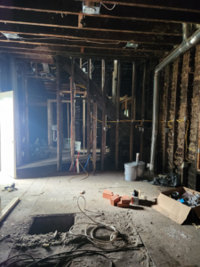 An interior home renovation project with exposed studs and wiring by She Builds Indy GC in Indianapolis, IN.