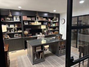 Home office with dark gray built-in bookshelves and a large desk by HomePro Improvements, Roswell, GA.