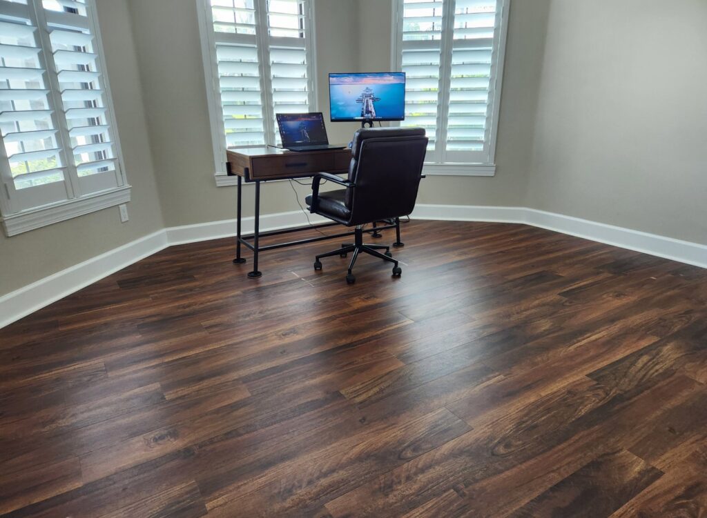 A newly installed dark wood-look flooring in a home office, a renovation project by Stormtroopers Home Improvement in Port St. Lucie, FL.