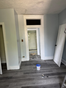 Home renovation showing doorway trim work and paint preparation by JW Contracting Services, LLC, leading to a bathroom in Dayton, OH.