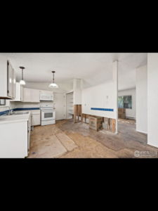 Interior home renovation with exposed subfloor and a partially demolished wall, handled by Radiant Homes LLC in Denver, CO.