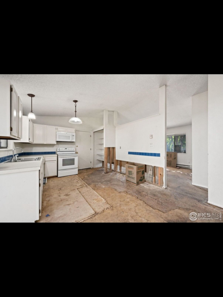 Interior home renovation with exposed subfloor and a partially demolished wall, handled by Radiant Homes LLC in Denver, CO.