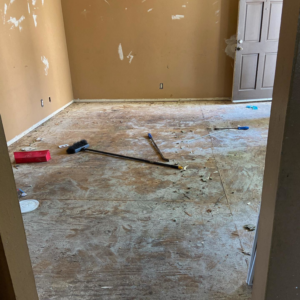 A home renovation project showing an exposed subfloor and tools by Premier Home Services in Fullerton, CA