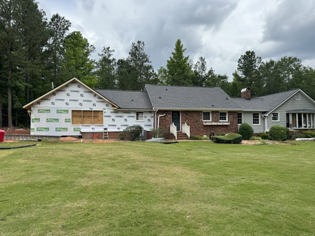 A house undergoing renovation with new framing and house wrap, a handyman service by Blue Wing Roofing in Augusta, GA