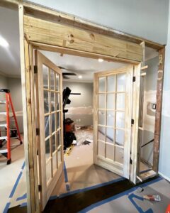 A home renovation in progress, showing new wooden framing and French doors being installed by J.C.Improvement in Katy, TX.
