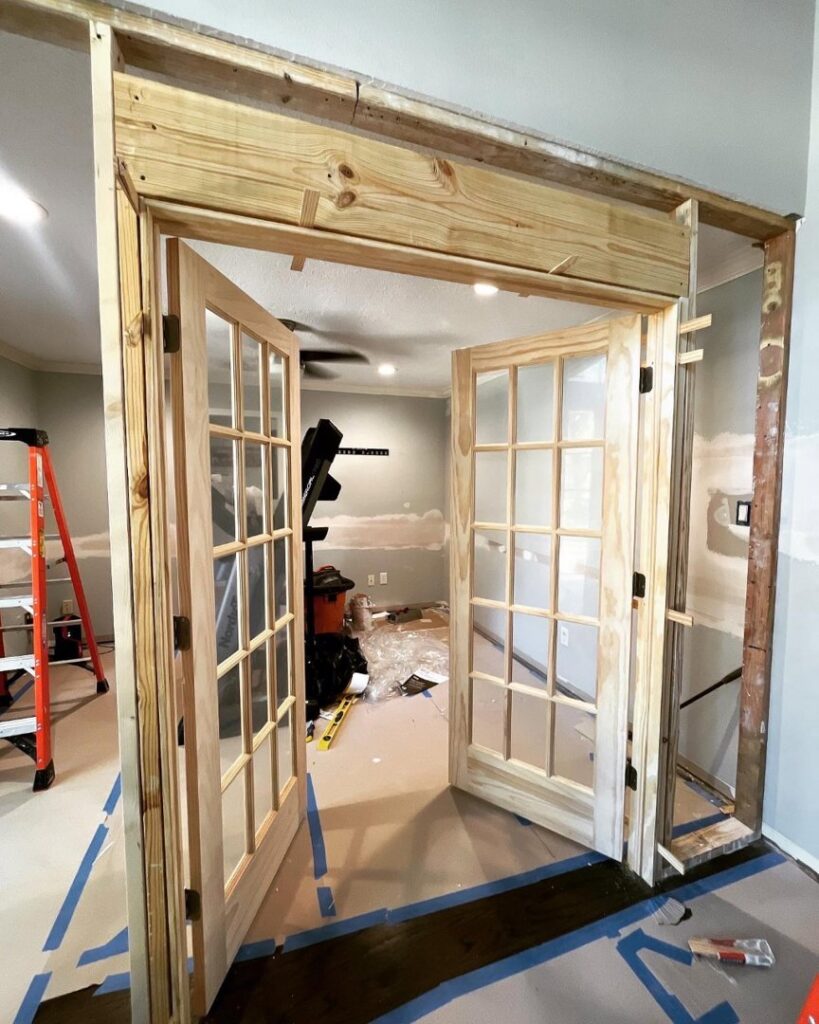 A home renovation in progress, showing new wooden framing and French doors being installed by J.C.Improvement in Katy, TX.