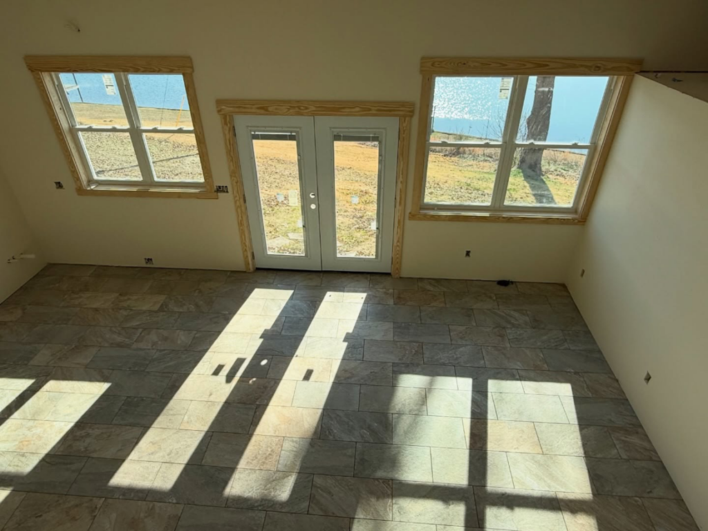 Renovated interior room with newly tiled floor, windows, and double door by Volunteer Building Services, Knoxville, TN.