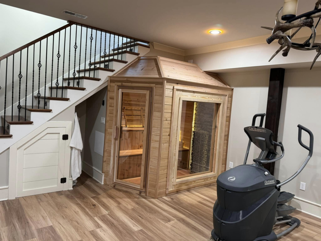 A home sauna installation under a staircase, showcasing the work of Upstate Modern Builders LLC in Greenville, SC.